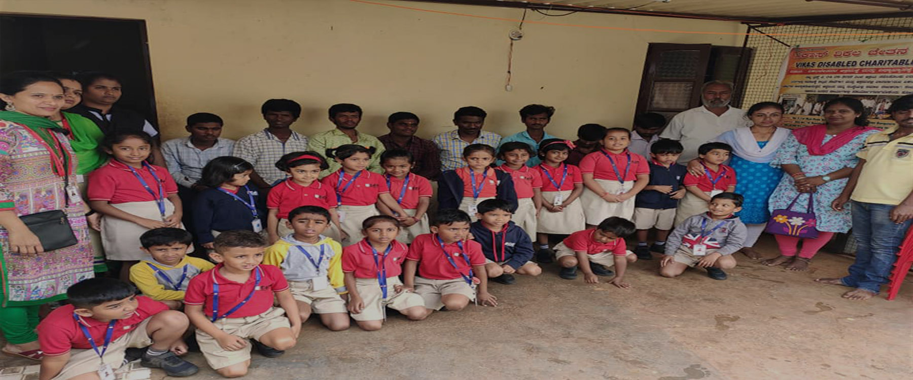 Children in school uniform with teachers and staff of Vikas Disabled Charitable Trust